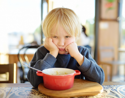 Food for Thought Therapy | How Can I Better Understand Selective Eating and What It Stems From? | Color image of girl resting her face on her hands, upset, with a bowl of food in front of her